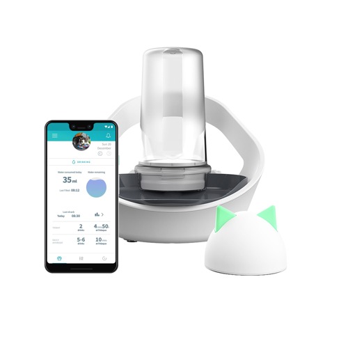 A white plastic cat water bowl with a clear bottle on top of it to dispense water from. Next to it is a smartphone showing the Sure Petcare app and a hub device that is a white dome with green cat ears on top