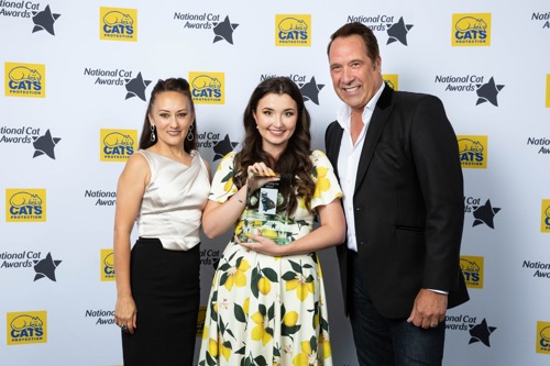 three people stood in front of National Cat Awards backdrop