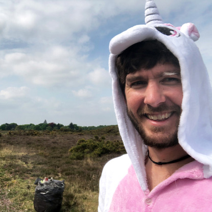 man in unicorn onesie with bin bags