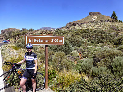 female cyclist by sign for El Retamar