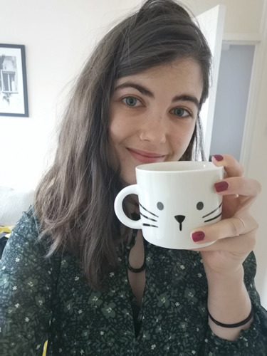 brunette woman holding white cat mug