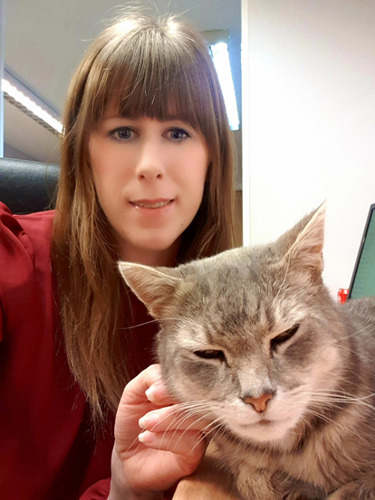 brunette woman stroking grey tabby cat